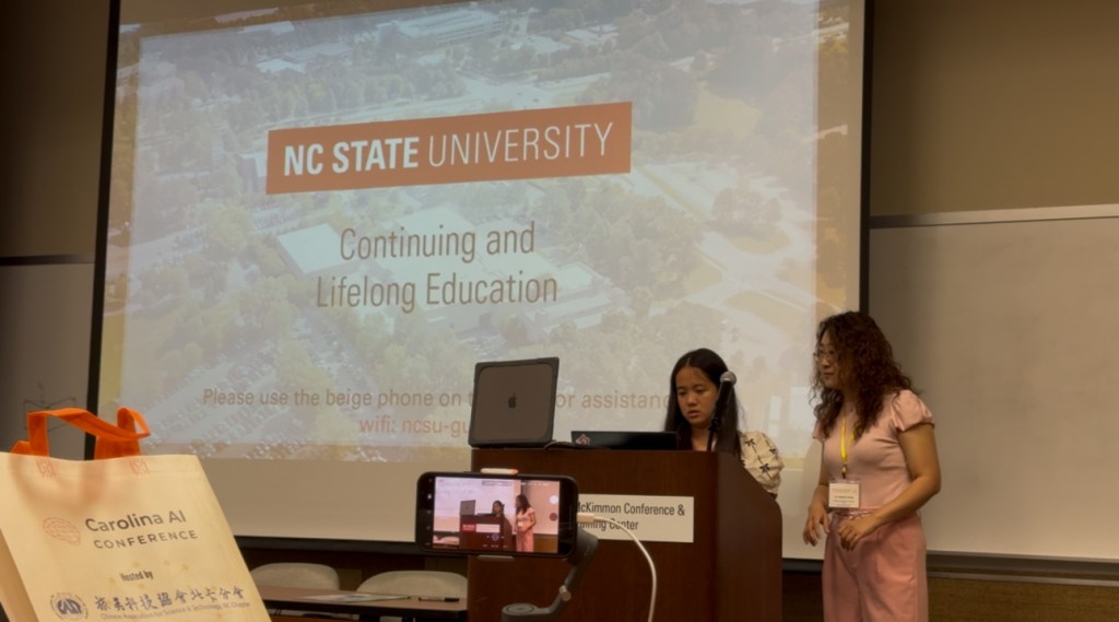 Dr. Zhang leading a female student to help set up her powerpoint presentation during Youth Track at the 2025 Carolina AI Conference